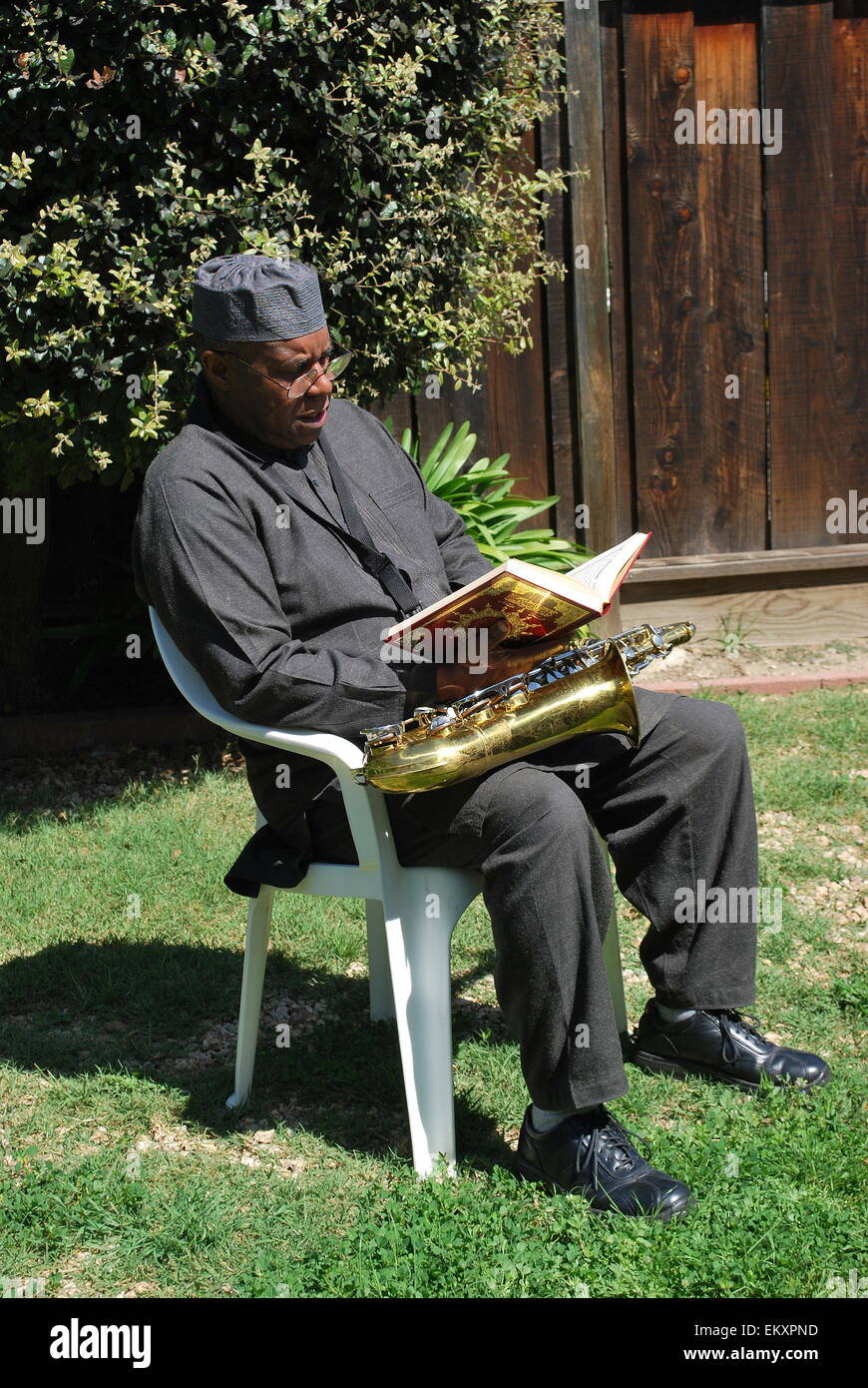 Uomo musulmano la lettura al di fuori. Foto Stock