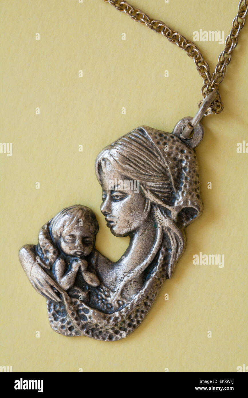 Azienda madre baby collana pallido su sfondo giallo Foto Stock