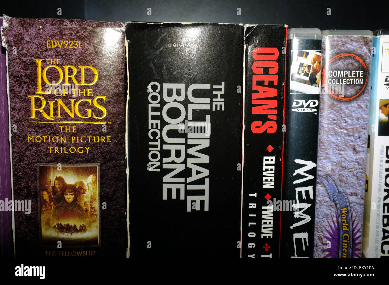 Una selezione di DVD e la casella imposta su un ripiano. Foto Stock