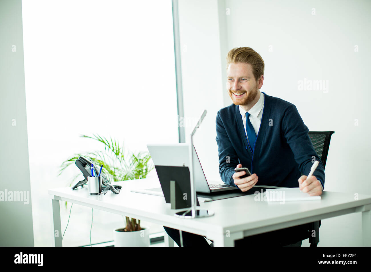 Giovane uomo che lavora in ufficio Foto Stock