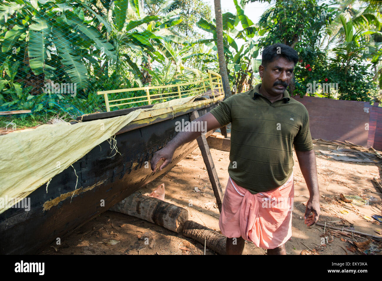 Abitante spiegando come canoe sono realizzati nelle backwaters di Kumarakom Kerala India Foto Stock