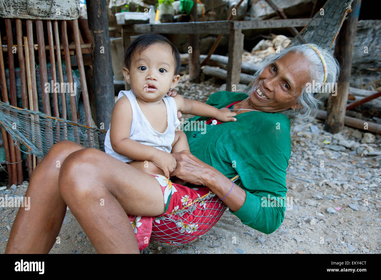 Una nonna detiene il suo nipote in un villaggio; El Nido Arcipelago Bacuit PALAWAN FILIPPINE Foto Stock