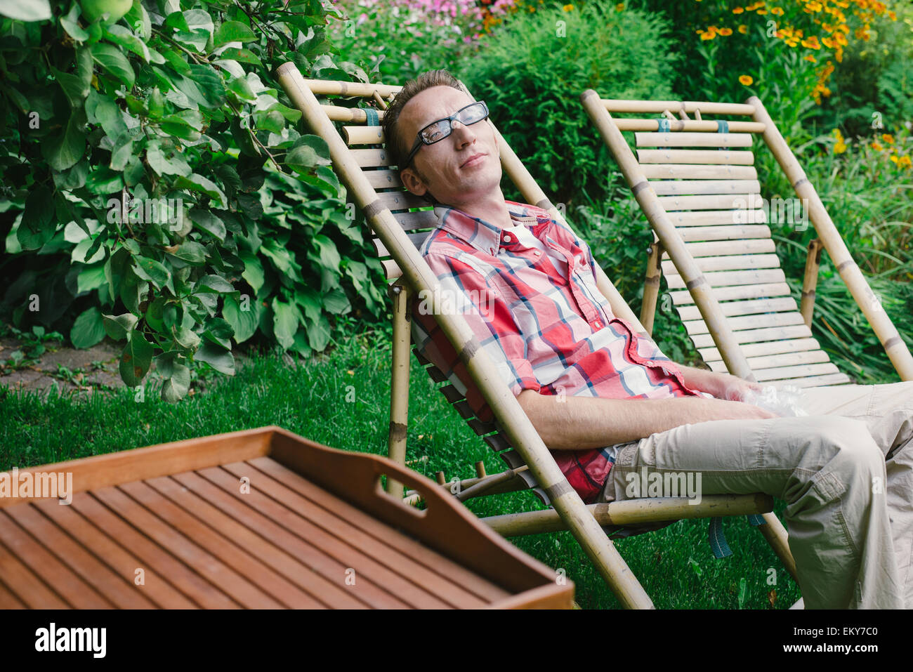 Uomo relax outdoor nel suo giardino a giorno di estate Foto Stock