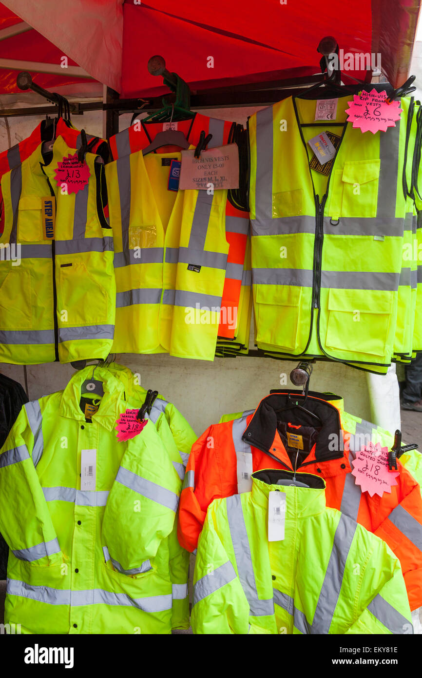 Hi-viz giacche e giubbotti in vendita appesa in un mercato in stallo, Loughborough. Foto Stock