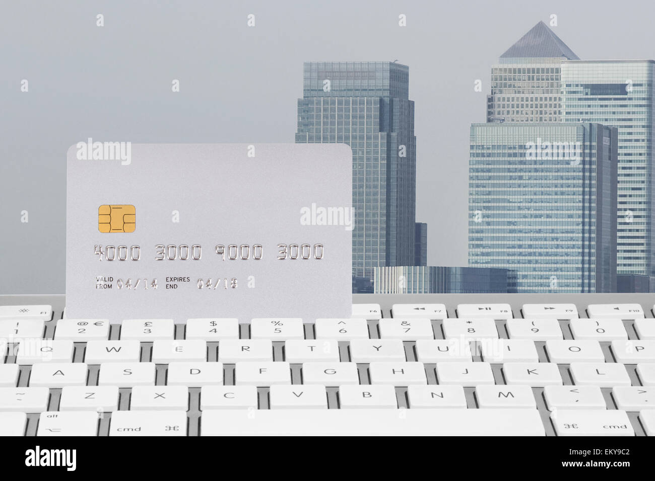 Carta di credito sulla tastiera di un computer con Canary Wharf Financial District in background Foto Stock