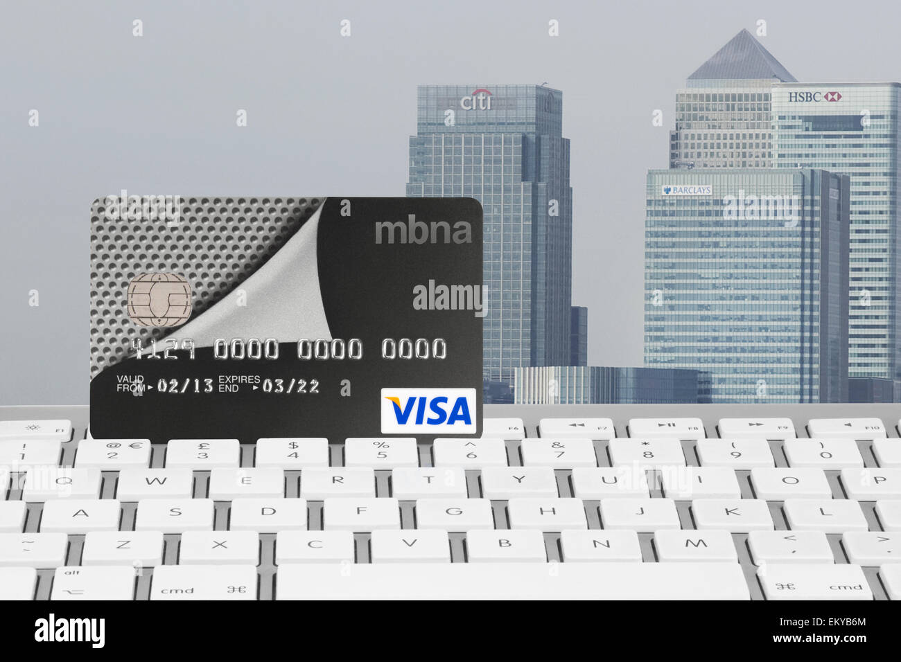 MBNA Visa carta bancaria sulla tastiera di un computer con Canary Wharf Financial District in background Foto Stock