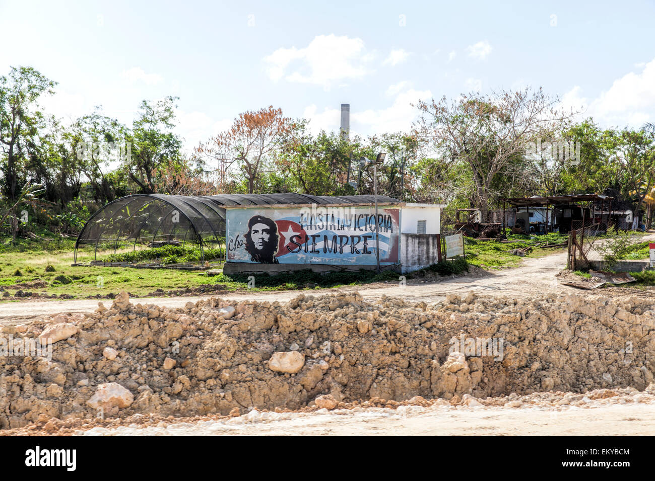 Sulla parete di un edificio in una parte remota di Cuba con un murale con la bandiera cubana, immagine di Che Guevara e un rivoluzionario di slogan. Foto Stock