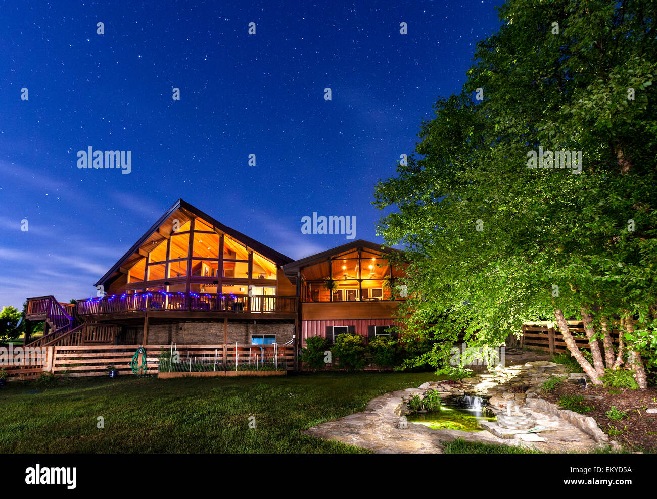 Casa moderna con koi pond sotto il cielo stellato Foto Stock