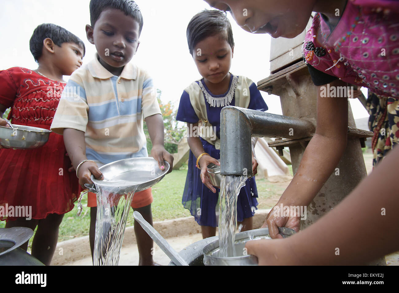 Bambini lavare i piatti dopo un pasto; India Foto Stock