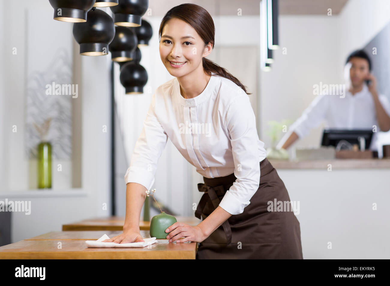 Giovane cameriera tergi tabella Foto Stock