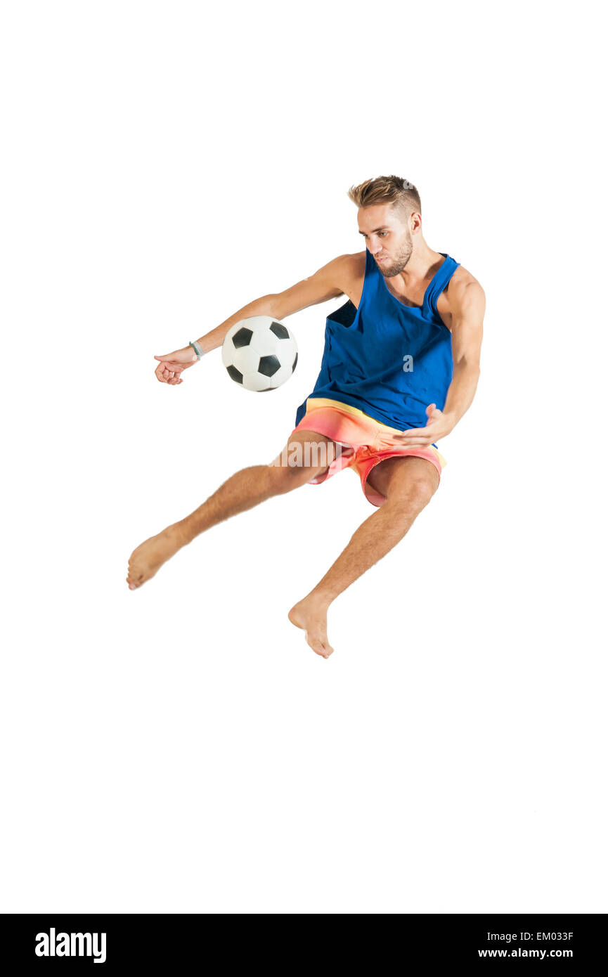 Giovane ragazzo attraente giocando con il calcio su sfondo bianco Foto Stock