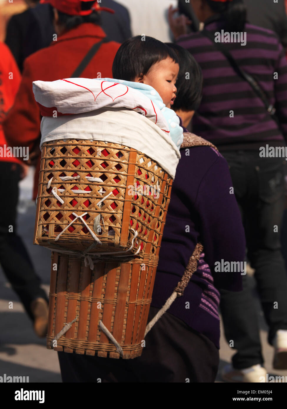 Donna con bambino vettore sulla sua schiena nella Città Proibita, Pechino Foto Stock