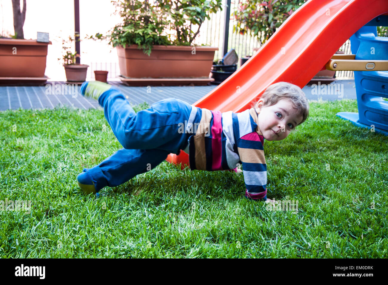 Due fratelli giochi nel giardino sulla diapositiva Foto Stock