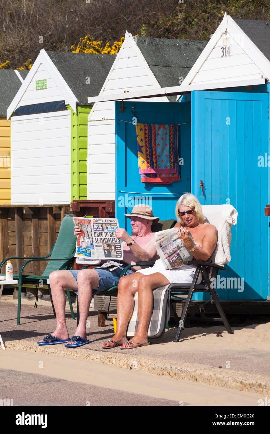 Bournemouth Dorset, Regno Unito. Il 15 aprile, 2015. Regno Unito Meteo: i visitatori fanno la maggior parte del caldo clima soleggiato a Bournemouth Beach, Dorset, Regno Unito come forecasters predire che sarà il giorno più caldo dell'anno in UK con temperature nella metà 20s - coppia di crogiolarvi al sole la lettura giornali fuori beach hut Credito: Carolyn Jenkins/Alamy Live News Foto Stock