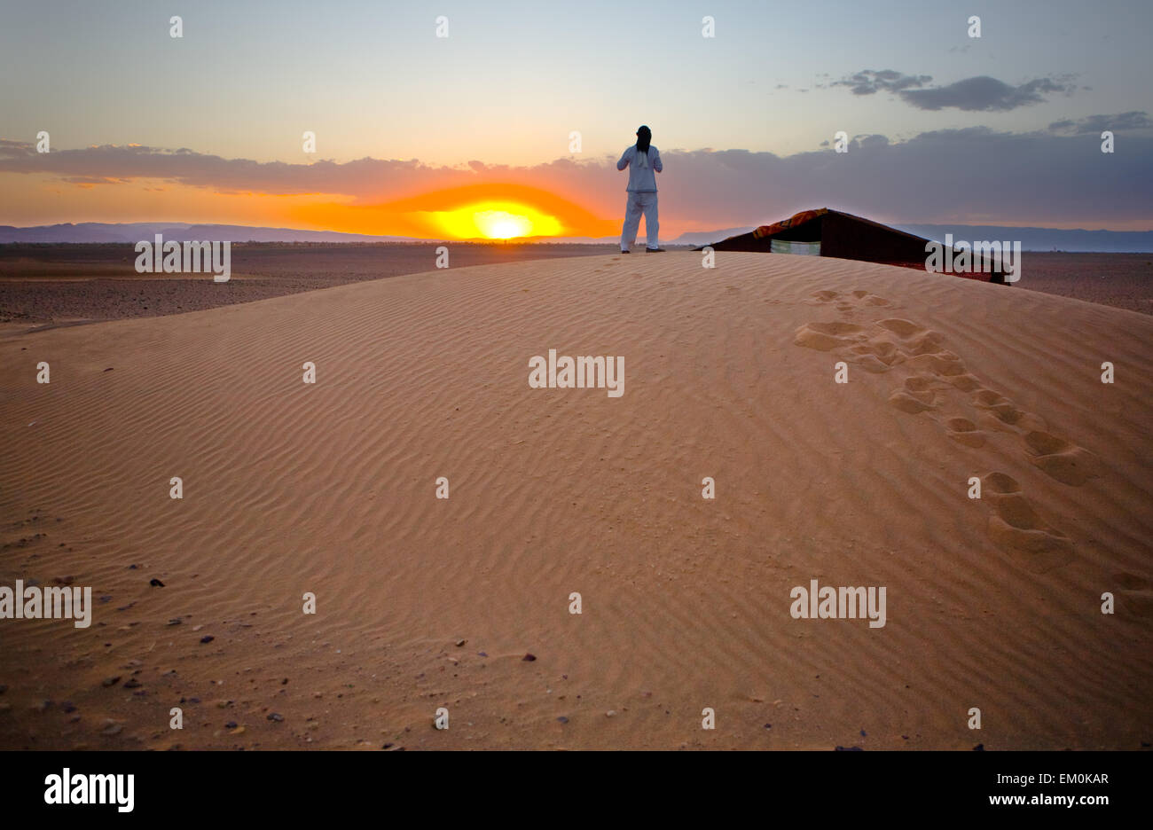 Deserto del Sahara area porte di scena. Un uomo prende le immagini sulla sommità della duna, Zagora, Marocco Foto Stock