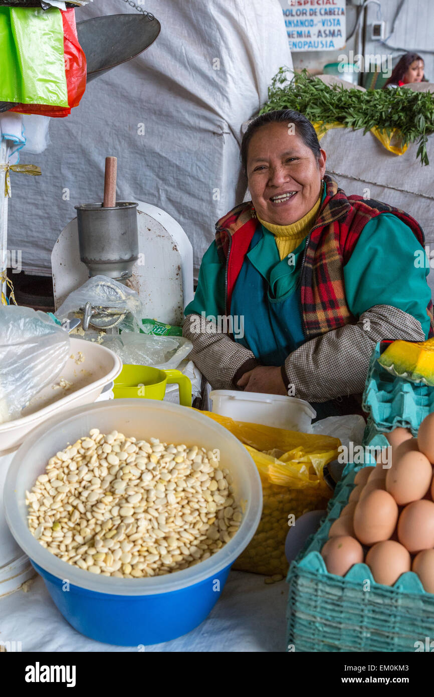 Perù Cusco, San Pedro mercato. Donna vendita di uova, fagioli e melone. Foto Stock