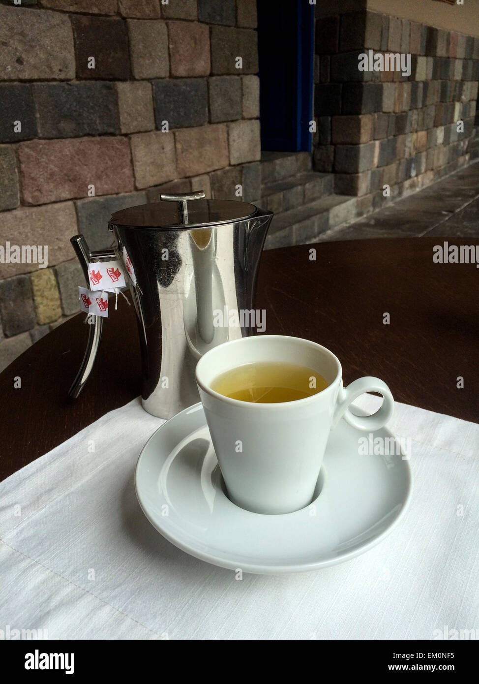 Il Perù. Il tè di coca, detto per attenuare i sintomi del malessere da altitudine a Cusco's 11.000 piedi di altitudine. Inca murature in background Foto Stock