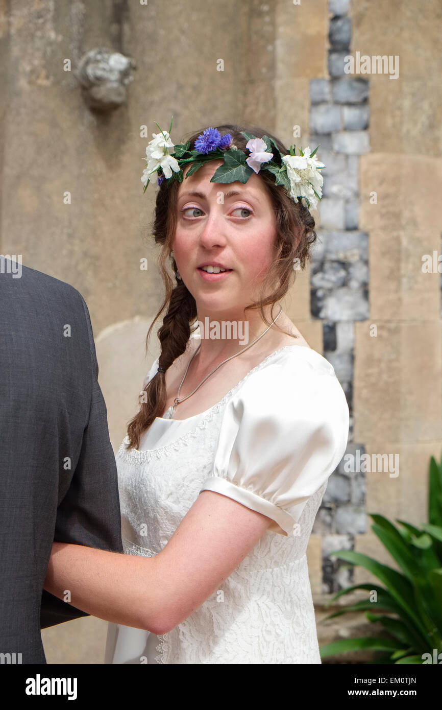 Sposa entrando in chiesa sul braccio di suo padre e guardando indietro Foto Stock