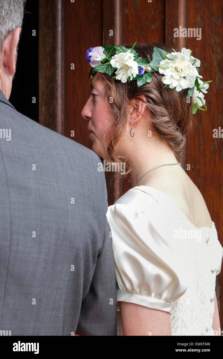 Sposa entrando porta della chiesa sul braccio di suo padre Foto Stock