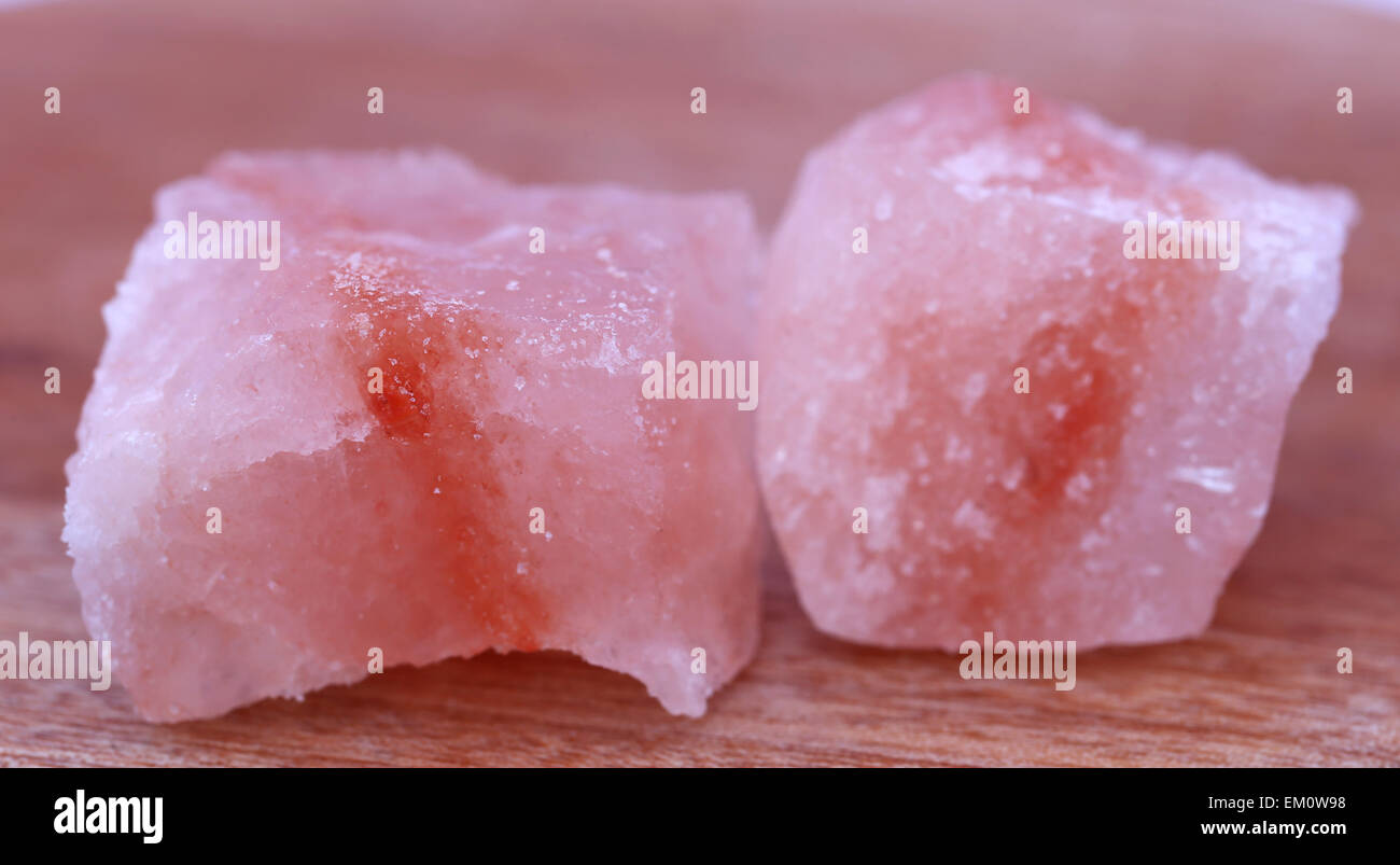 Saindhava lavana o Rosa himalayano sale di roccia su una superficie di legno Foto Stock