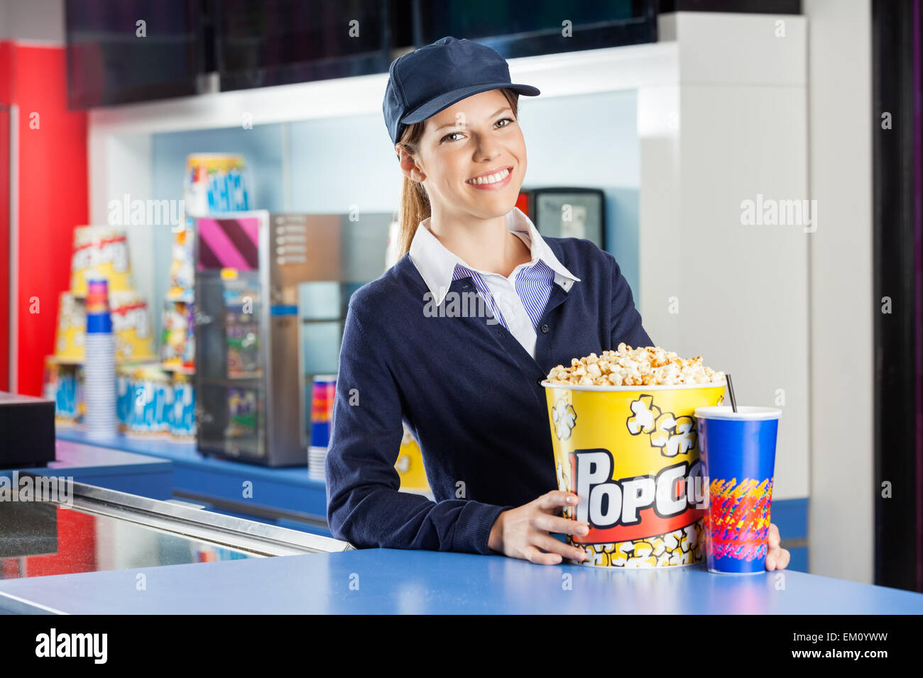 Fiducioso lavoratore con popcorn e bere alla concessione di stand Foto Stock