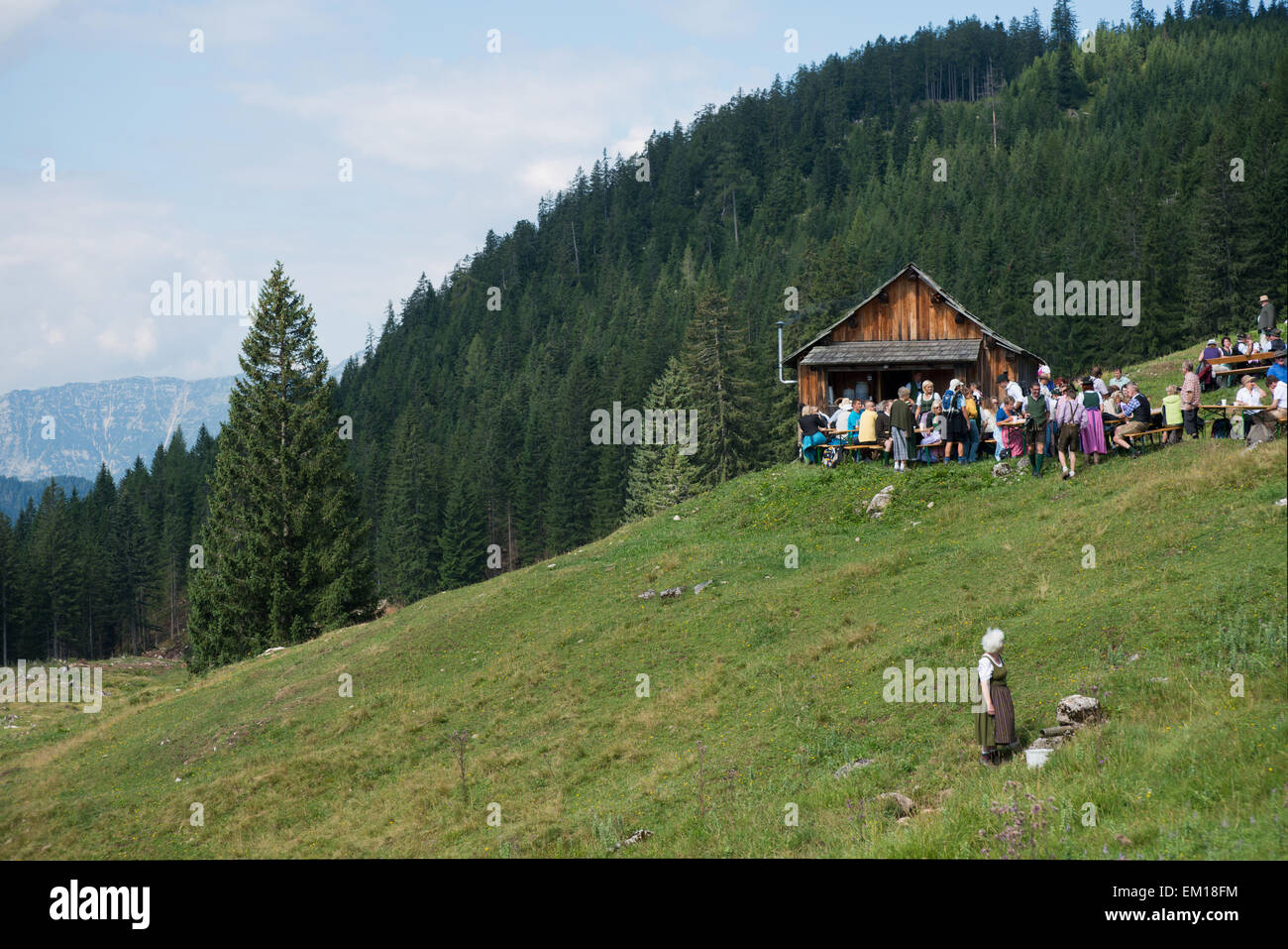 Musiker und Zuschauer bei einer Almhütte, dahinter Wald, am Pfeifertag auf der Weissenbachalm, Salzkammergut, Steiermark, Österreich Foto Stock