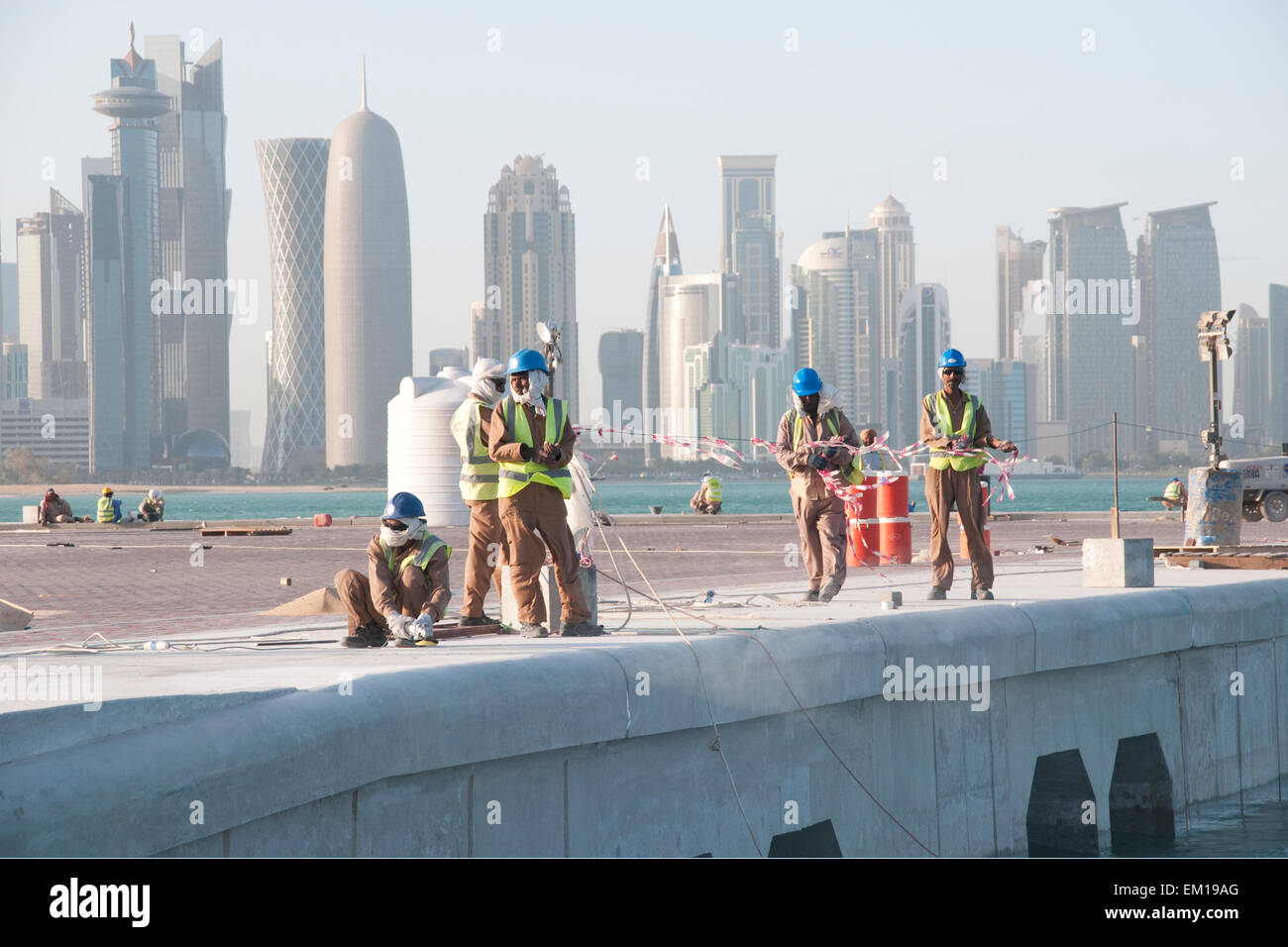 South Asian operai a lavorare presso un sito in costruzione nella città di Doha, nel golfo nazione del Qatar. Foto Stock