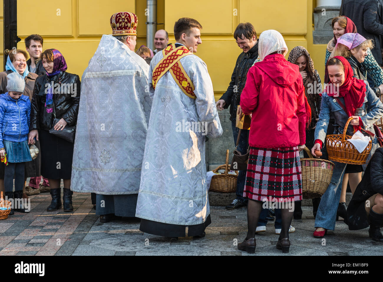 Sacerdote benedizione la gente allegra durante la Santa Pasqua Domenica cerimonia al di fuori di San Vladimiro's Cathedral di Kiev Foto Stock