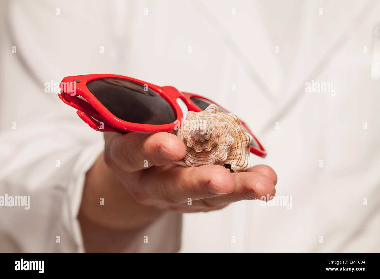 Medico è in possesso di occhiali da sole e la shell Foto Stock