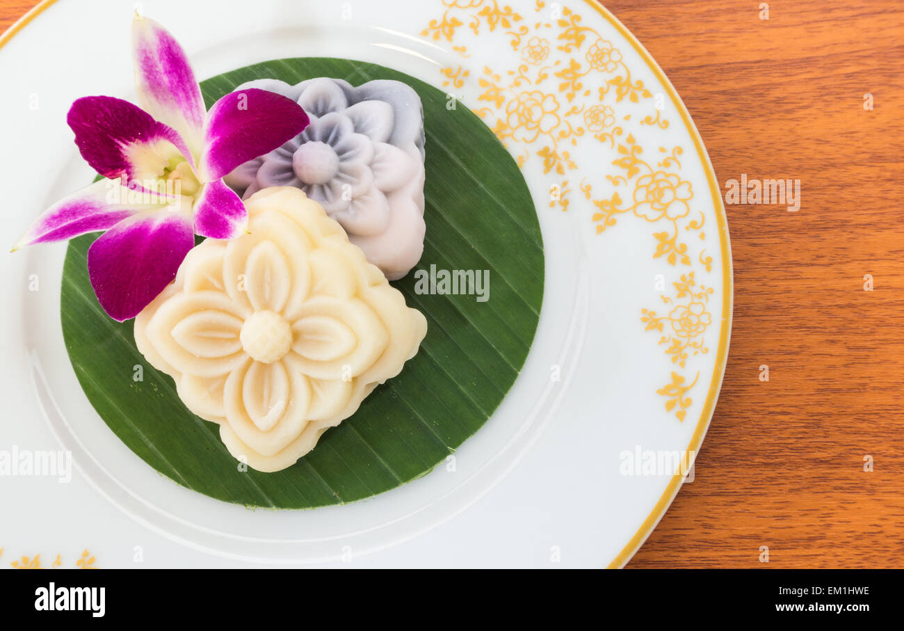 Thai dessert torta morbida con fiori di orchidea sulla piastra bianca Foto Stock