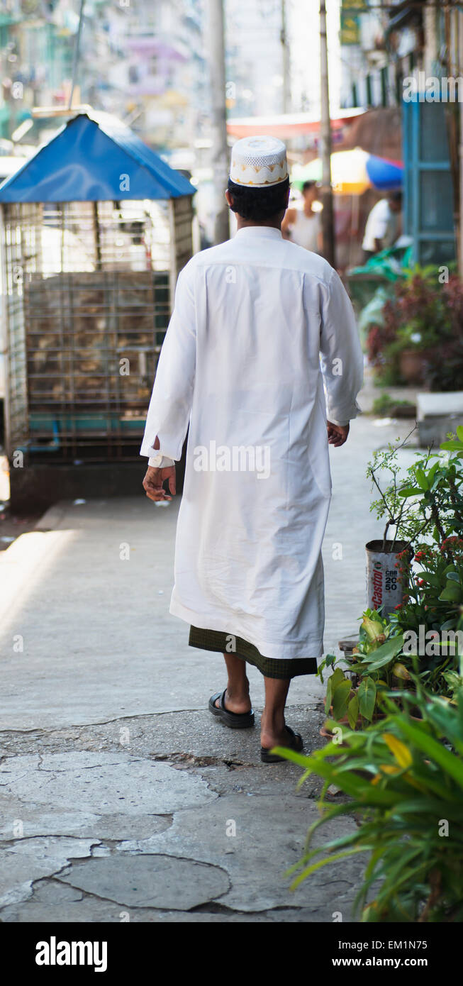 Un leader cammina per la strada che indossa il bianco; Rangoon, Birmania Foto Stock