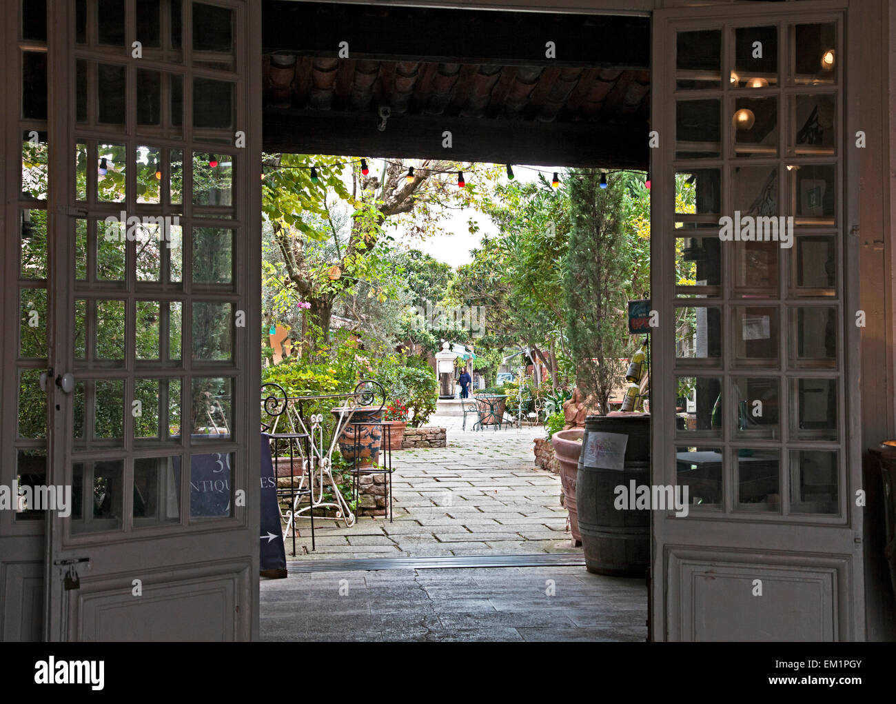 Ingresso a un patio pieno di negozi di antiquariato in 'Isle-sur-la-Sorgue in Provenza, Francia. Foto Stock