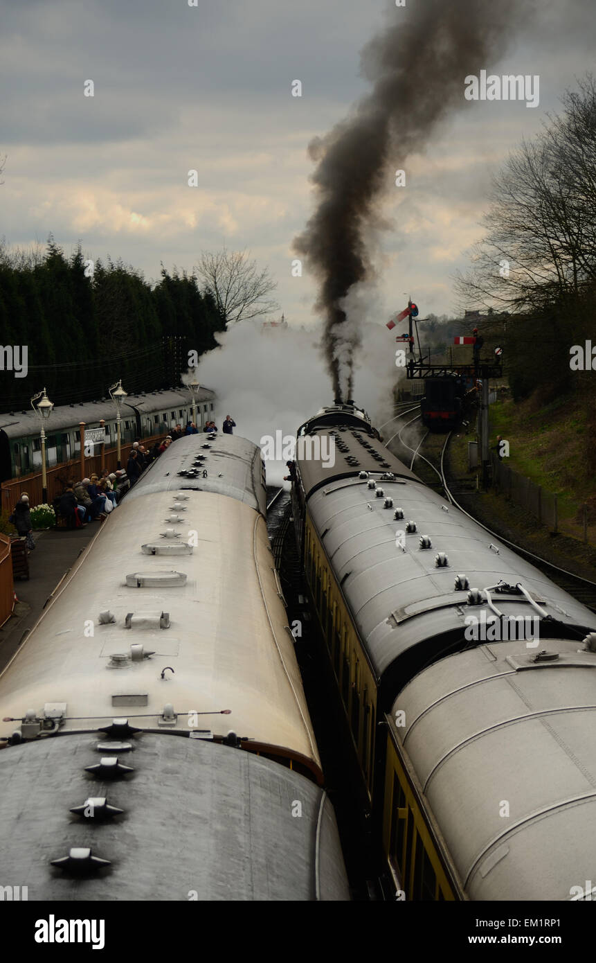 Un treno tira fuori di Bridgnorth stazione ferroviaria in Severn Valley Railway Line. Fumo nero e il vapore versare dal camino. Foto Stock