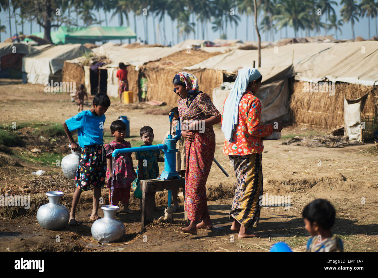 I rifugiati riempimento di vasetti con acqua potabile; Sittwe, Stato di Rakhine, Birmania Foto Stock