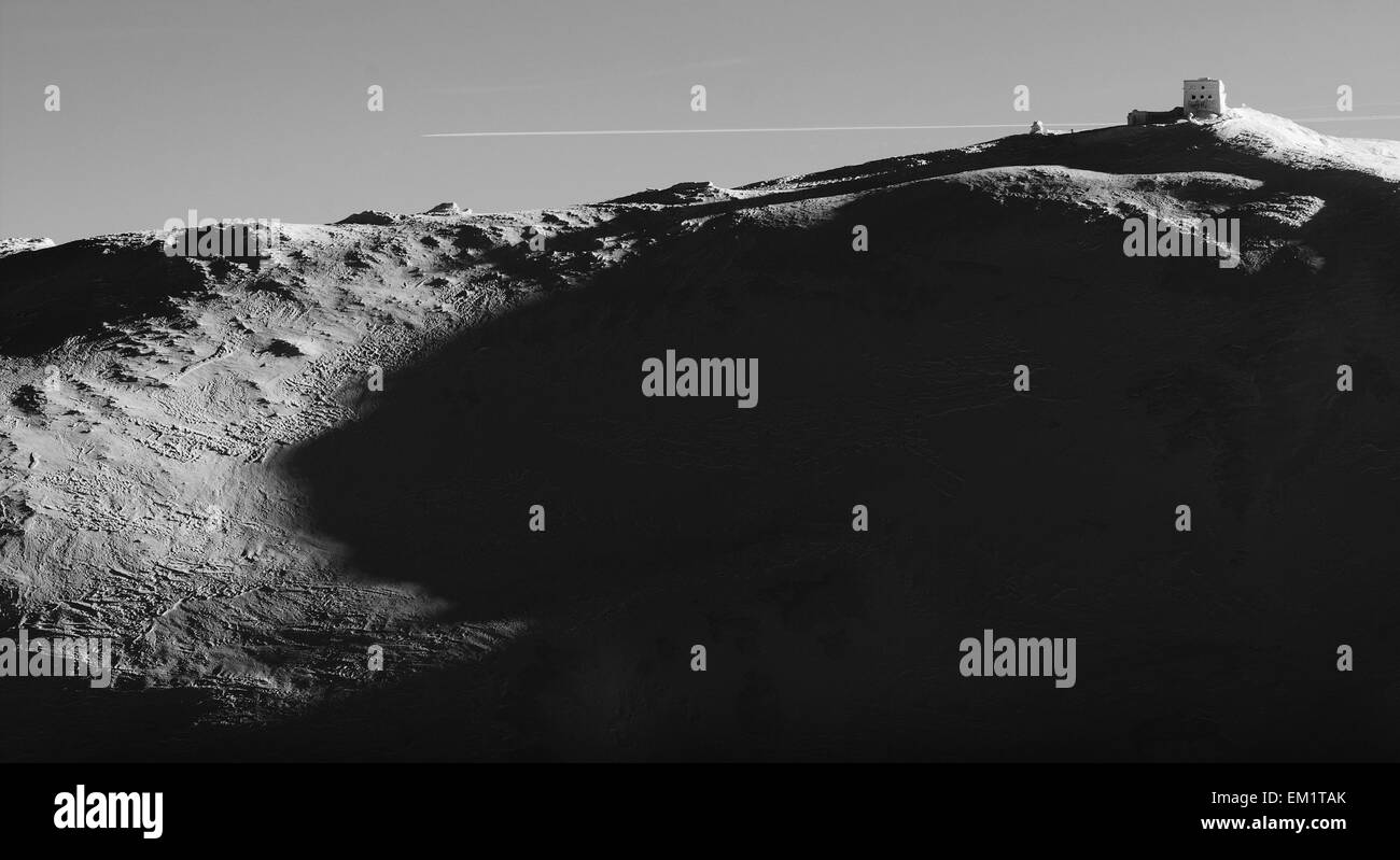 La fotografia in bianco e nero, edificio snow soffiare su una montagna alta. alto contrasto Foto Stock