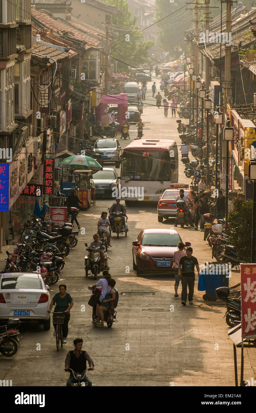 Scooters, traffico e pederstians tardo pomeriggio nel quartiere dello shopping, Lianyungang, Jiansu Provincia, Cina. Foto Stock