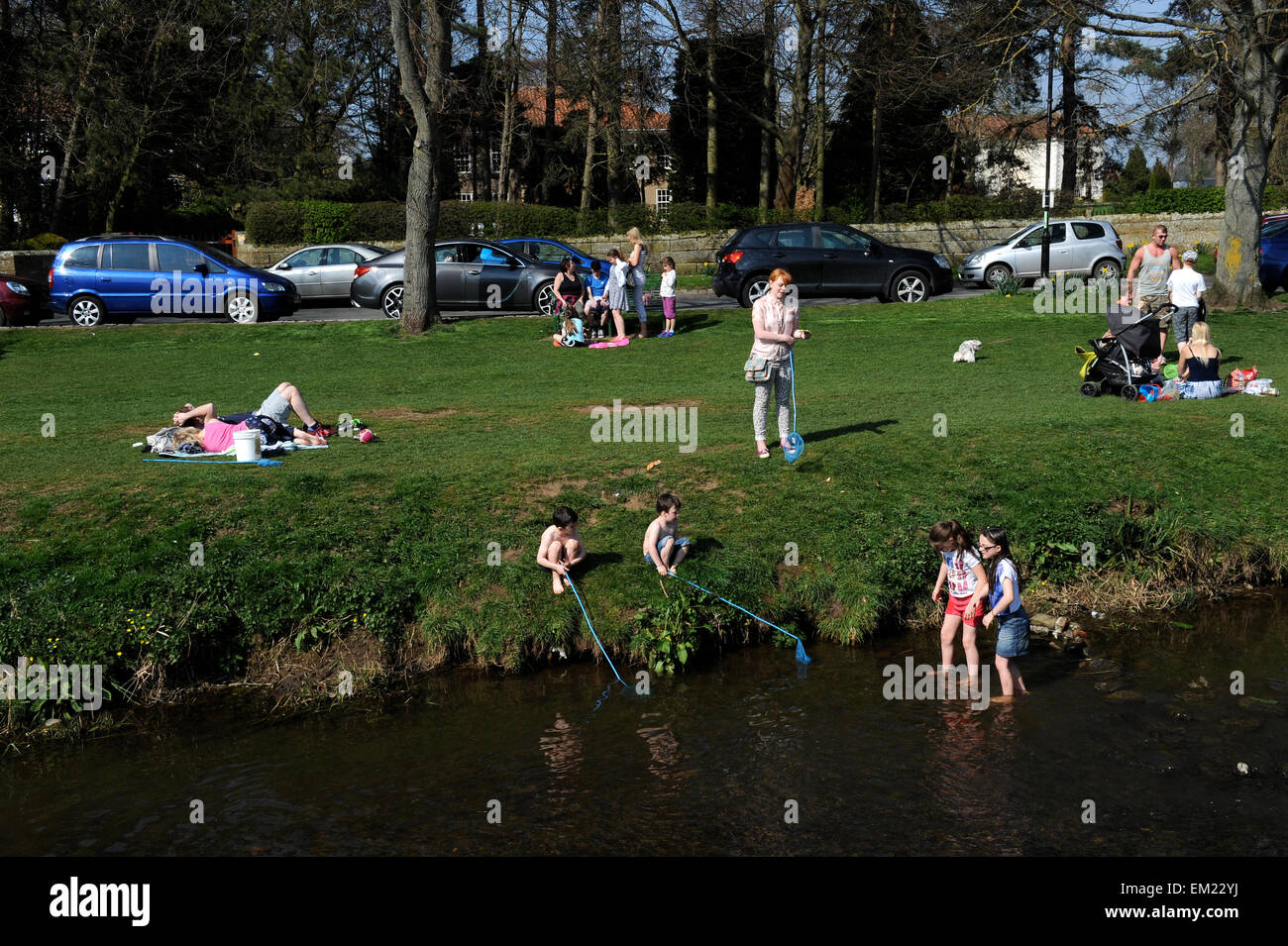 Famiglie paddling e la pesca nel fiume Leven in grande Ayton, North Yorkshire UK Gran Bretagna. Foto Stock