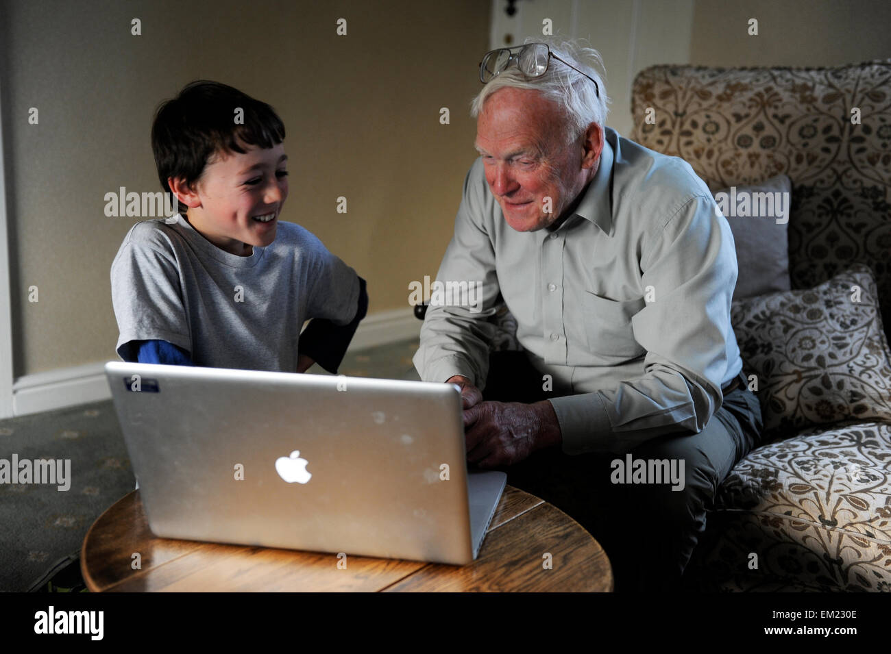 Nonno e nipote utilizzando portatile a casa Foto Stock