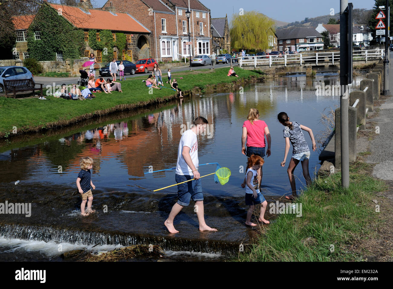 Famiglie paddling e la pesca nel fiume Leven in grande Ayton, North Yorkshire UK Gran Bretagna. Foto Stock