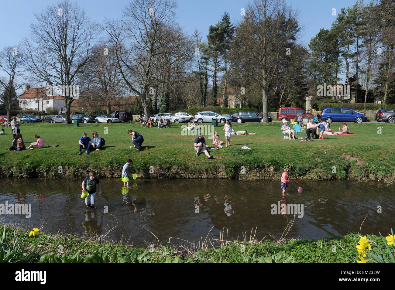 Famiglie paddling e la pesca nel fiume Leven in grande Ayton, North Yorkshire UK Gran Bretagna. Foto Stock