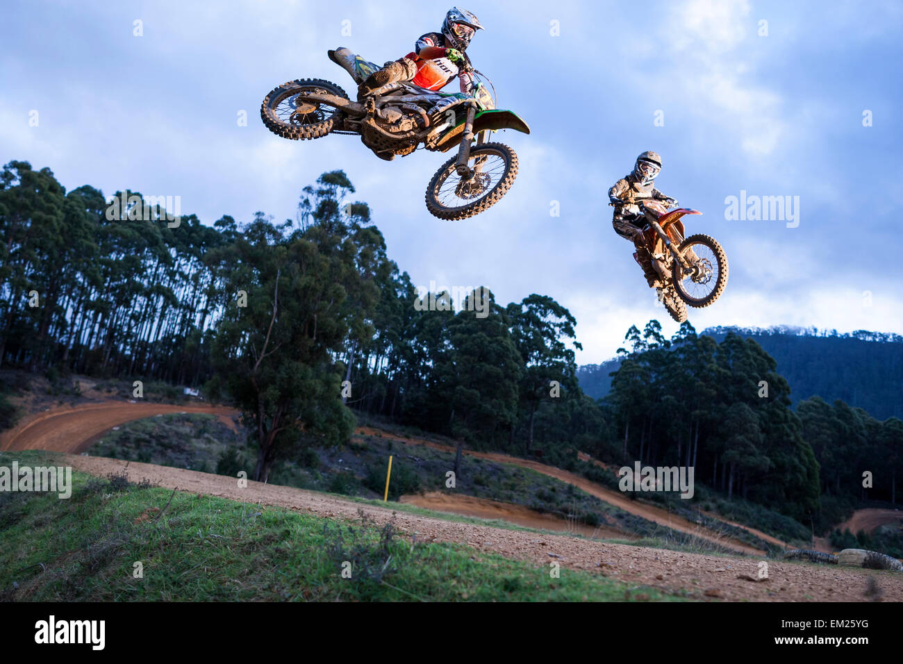 Due dirt bike racers saltando il piano portapaziente. Foto Stock