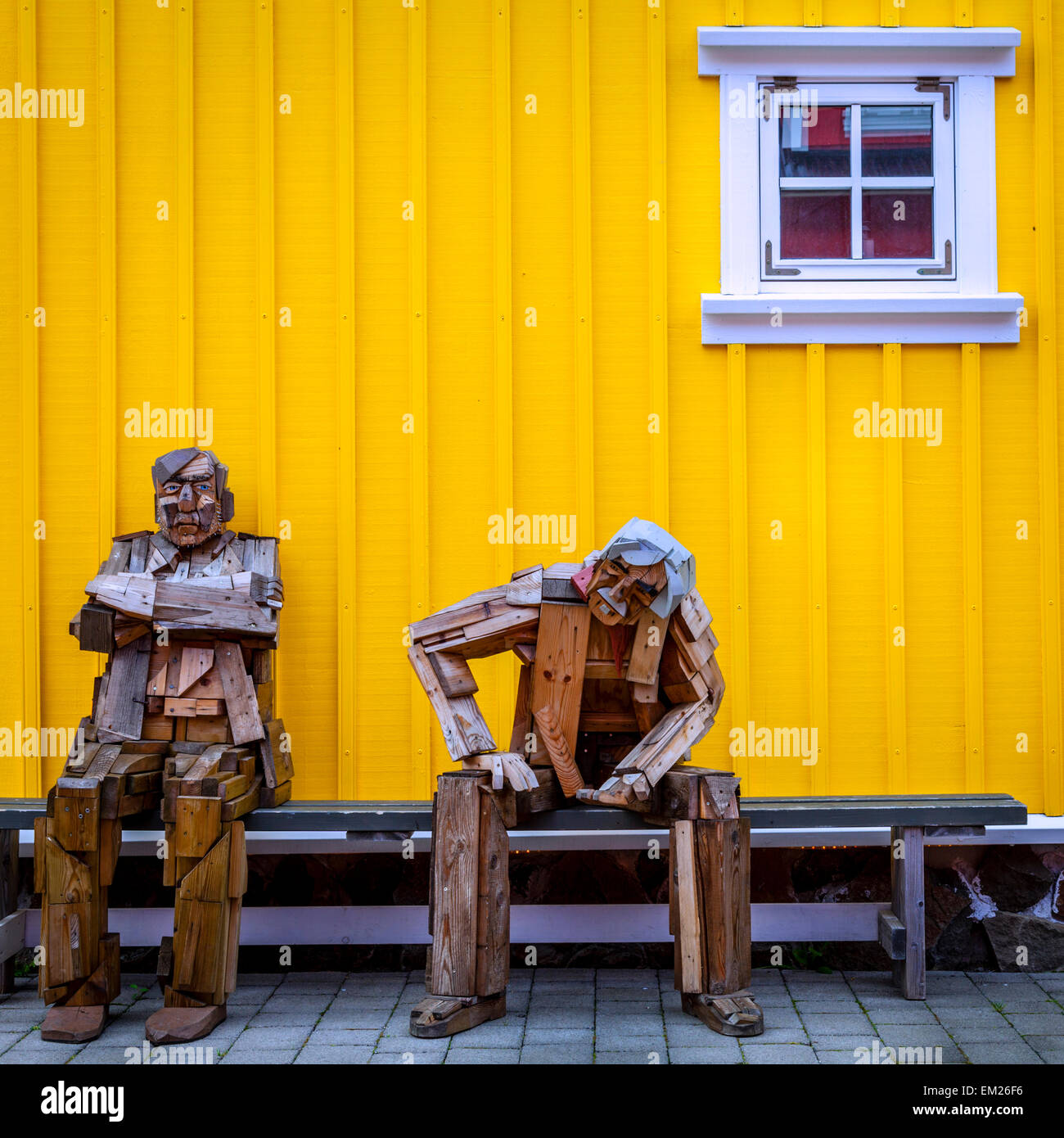 Scultura in legno composizione di due vecchi uomini su un banco in un piccolo villaggio di pescatori di Siglufjörður Affitto, Islanda Foto Stock
