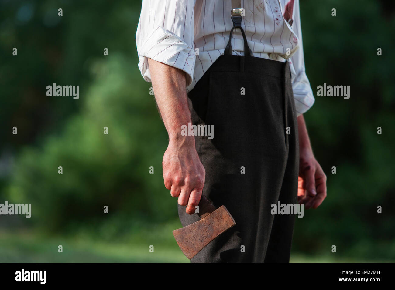 Un uomo con un ascia in mano. Foto Stock