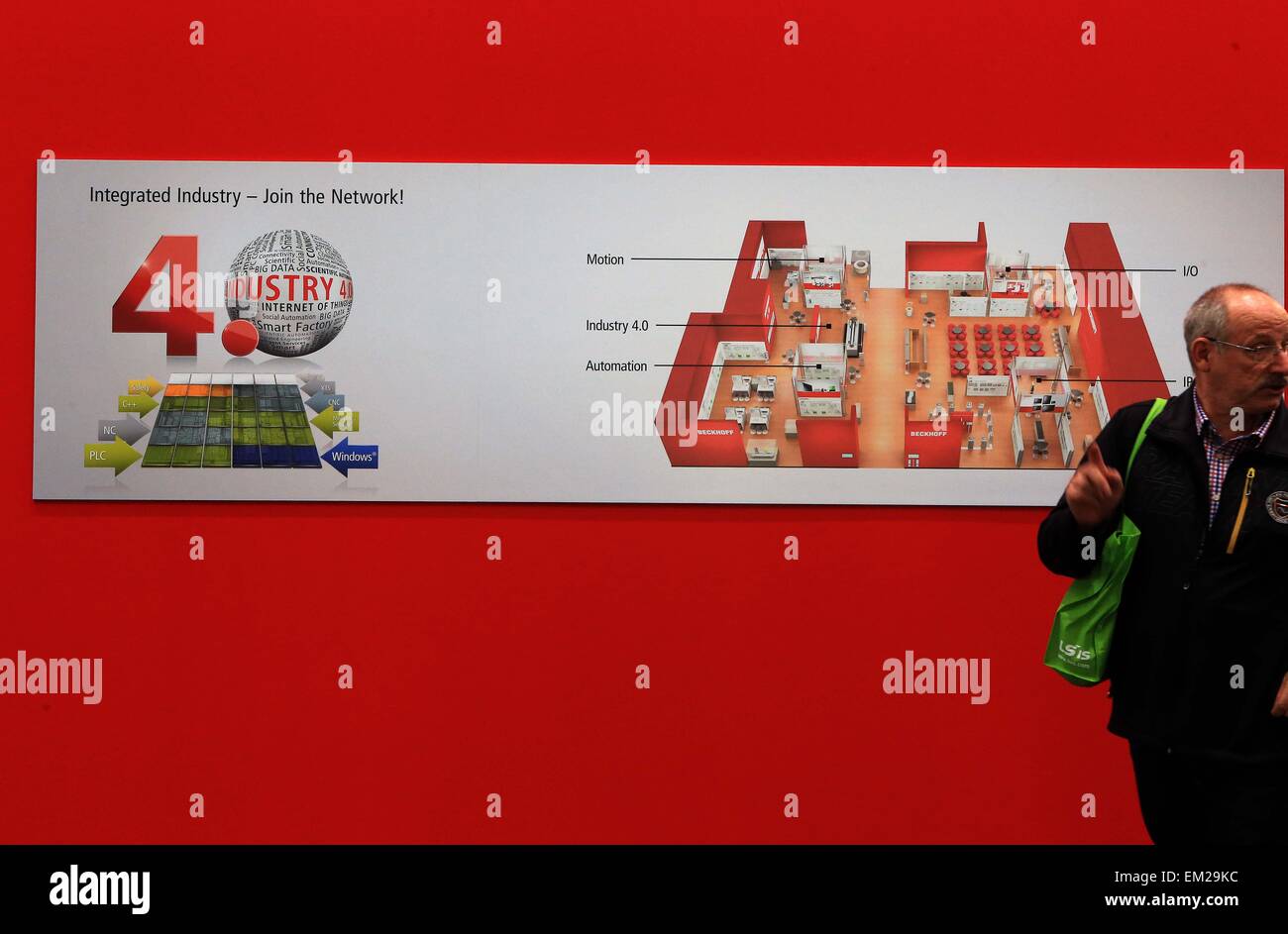 Hannover, Germania. Xiv Apr, 2015. Un visitatore passeggiate passato un poster a Hannover Industrial Fair, a Hannover, Germania, il 14 aprile 2015. La Hannover annuale fiera industriale di Hannover Messe, aperto ufficialmente Domenica notte, la focalizzazione per il terzo anno consecutivo l'integrazione dei tradizionali dell'industria e del settore IT. © Luo Huanhuan/Xinhua/Alamy Live News Foto Stock