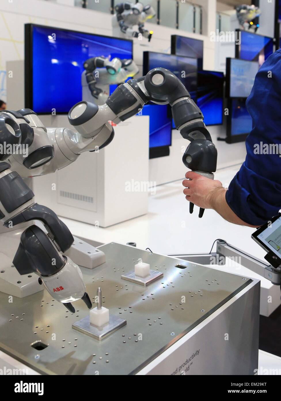 Hannover, Germania. Xv Apr, 2015. Un visitatore sperimenta la YuMi braccio robotico a Hannover Industrial Fair in Hannover, Germania, il 15 aprile 2015. La Hannover annuale fiera industriale di Hannover Messe, aperto ufficialmente Domenica notte, la focalizzazione per il terzo anno consecutivo l'integrazione dei tradizionali dell'industria e del settore IT. © Luo Huanhuan/Xinhua/Alamy Live News Foto Stock