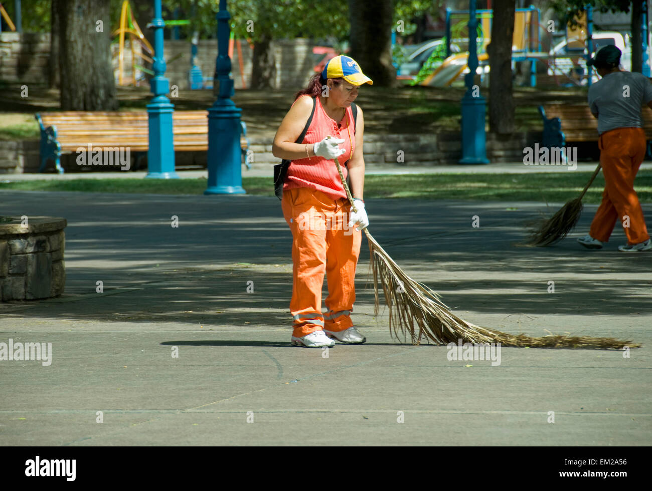 Città di spazzamento lavoratore una pubblica piazza con un albero di palma succursale; Mendoza Argentina Foto Stock