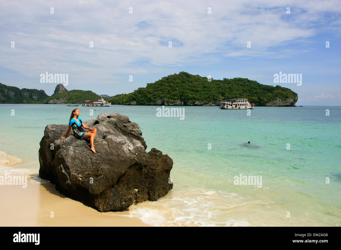 Giovane donna seduta su una roccia a Wua Talab isola, Ang Thong National Marine Park, Thailandia Foto Stock