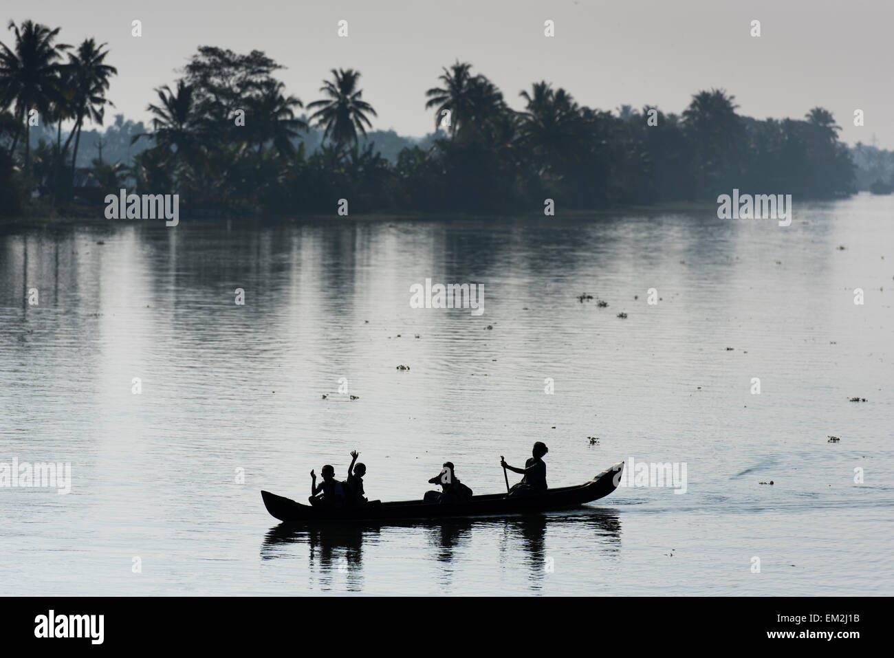 Donna di prendere i bambini a scuola in una piccola imbarcazione, Backwaters canal system, Kerala, nel sud dell'India, India Foto Stock