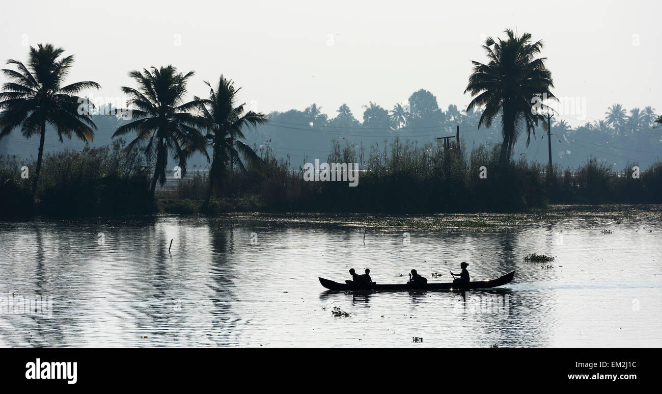 Donna di prendere i bambini a scuola in una piccola imbarcazione, Backwaters canal system, Kerala, nel sud dell'India, India Foto Stock