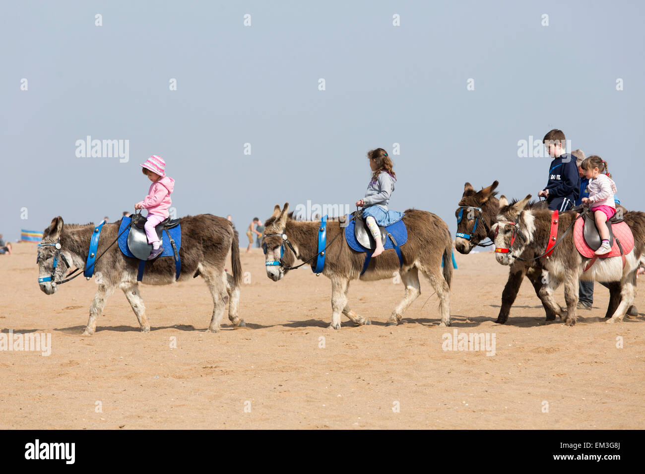 Le persone che si godono la spiaggia lungomare a Skegness in una giornata calda e soleggiata Foto Stock